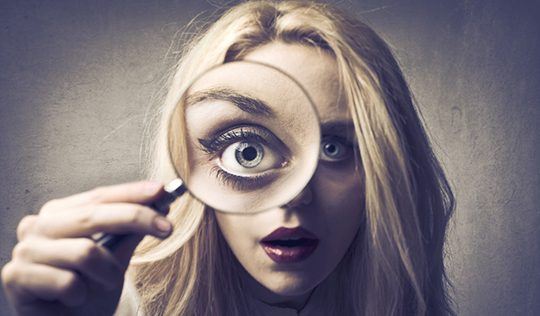 Woman with magnifying glass reading emotions