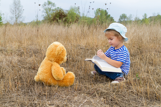 child reading story to teddy